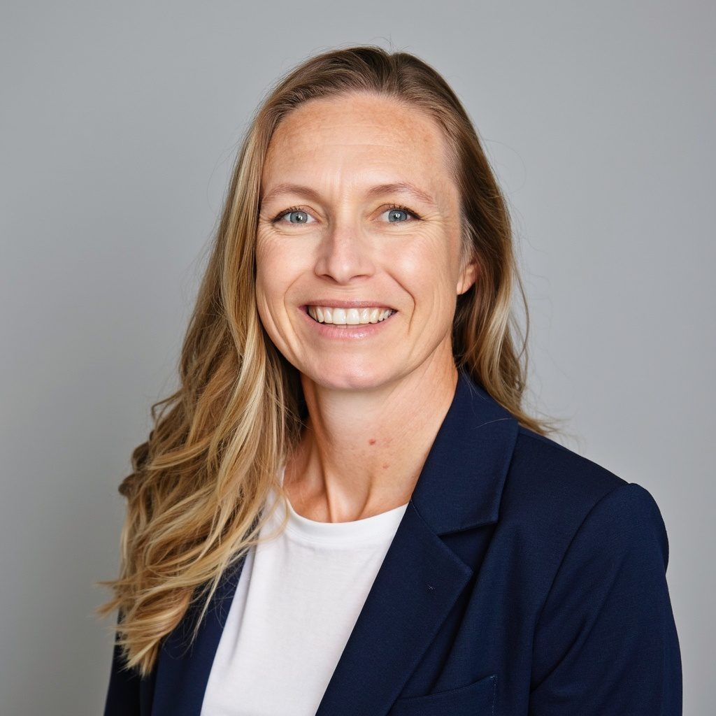 Smiling woman in blazer against gray background